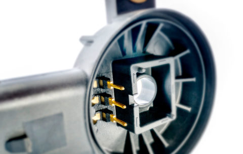 Hybrid housing with integrated metal pins and fastening bushings for efficient production.